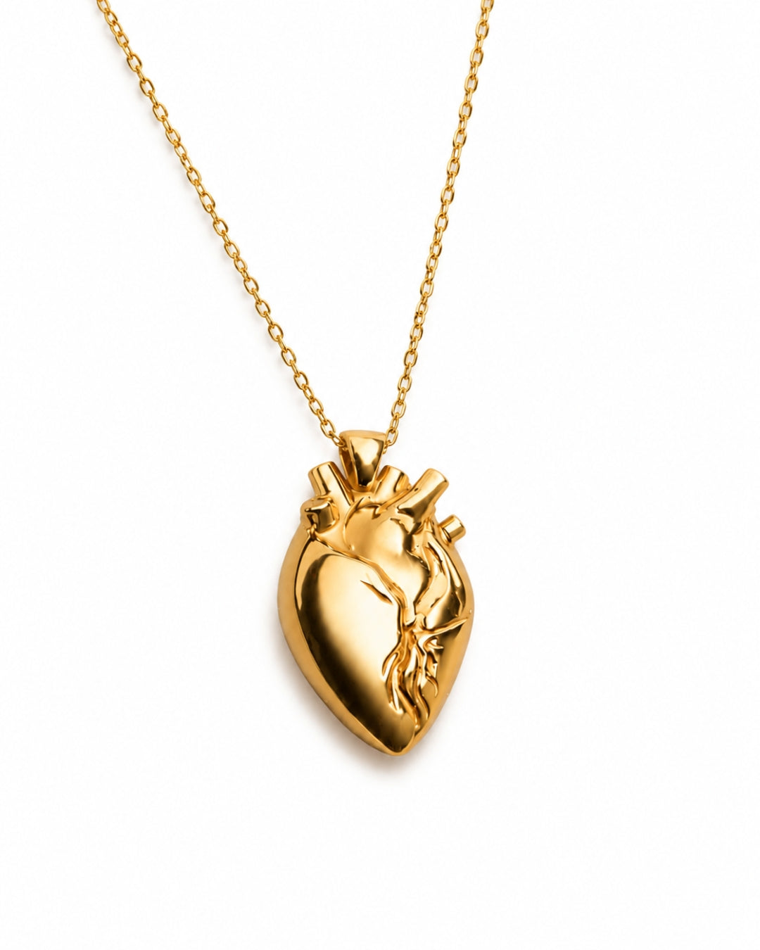 A gold anatomical heart pendant necklace on a delicate gold chain, shown against a plain white background.