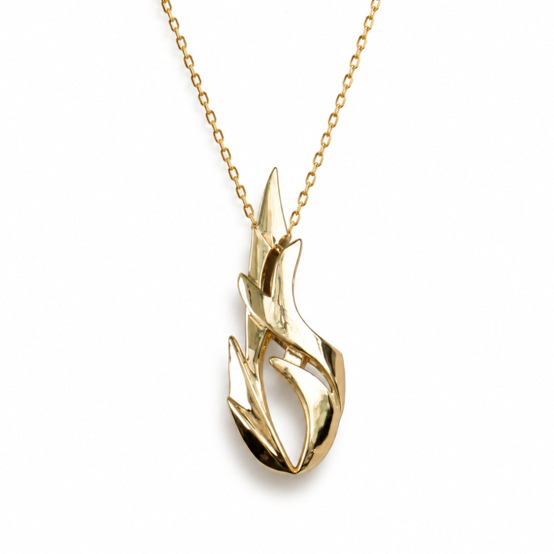 A gold necklace with a stylized flame-shaped pendant, shown against a plain white background.